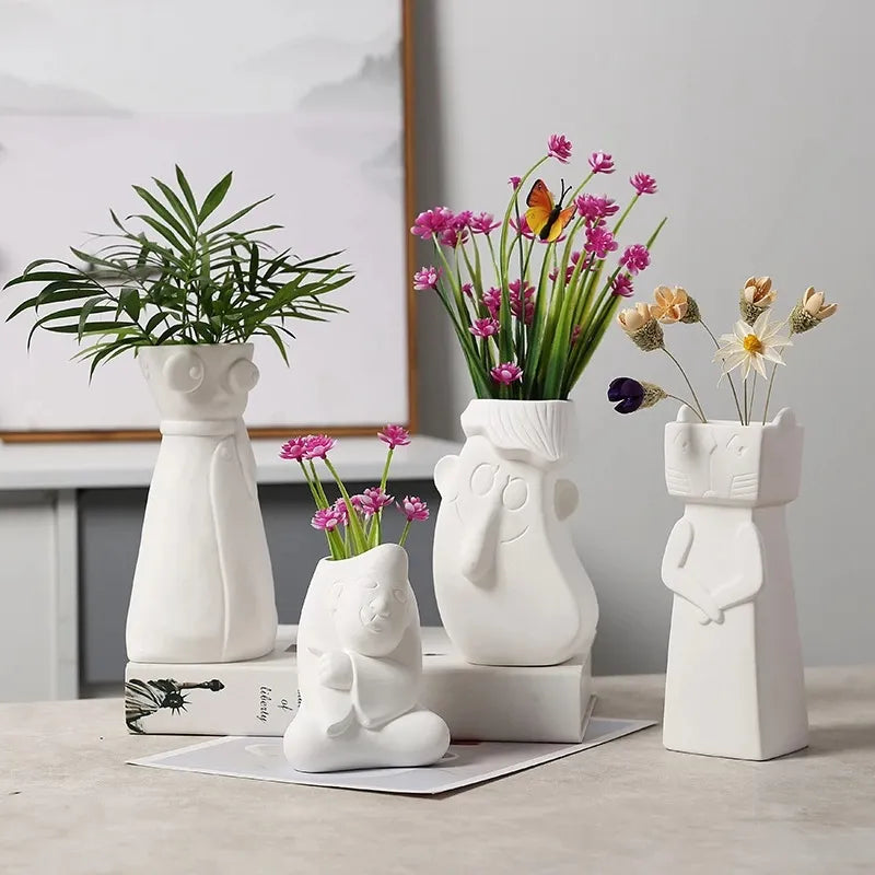 Set of four  White Ceramic vases with beautiful faces.