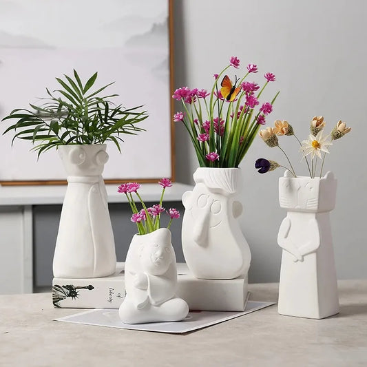 Set of four  White Ceramic vases with beautiful faces.